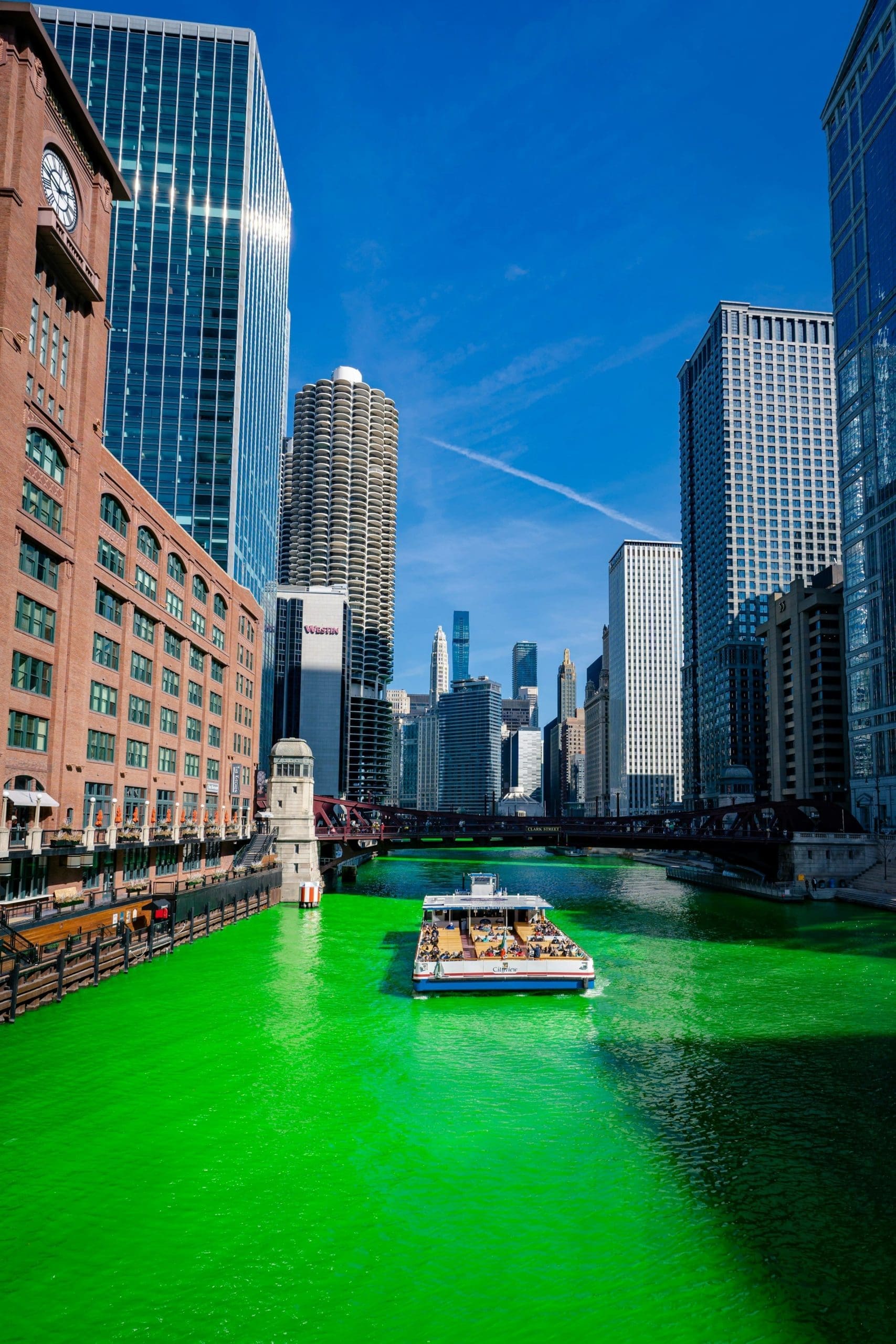 An image of a boat moving along a green dyed Chicago River.
